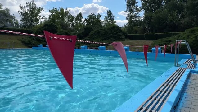 Red warning flags hanging over outdoor swimming pool