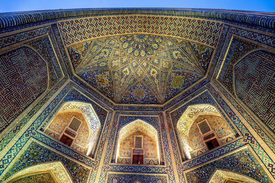 Madrasa architecture showcases intricate tile work and patterns at Tilla Kari in Samarkand, Uzbekistan during the evening