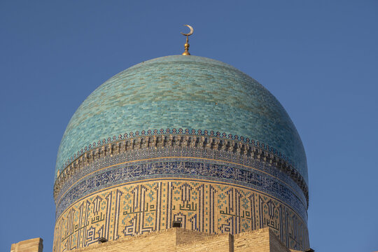 Kalon mosque dome showcases intricate tile work and a crescent moon emblem over Bukhara