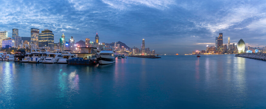 View of Causeway Bay harbour and city skyline at dusk with boats in water on Hong Kong Island