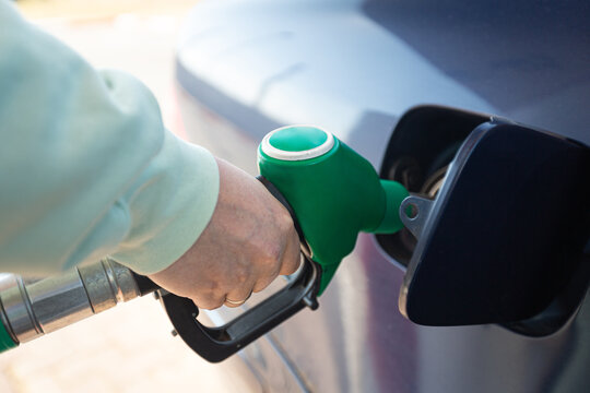 Man filling gasoline fuel in car holding pump