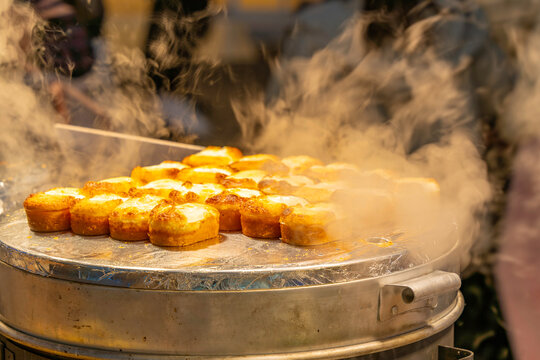 Hot food stalls attract shoppers on Myeongdong Shopping Street in Seoul at night with tempting aromas