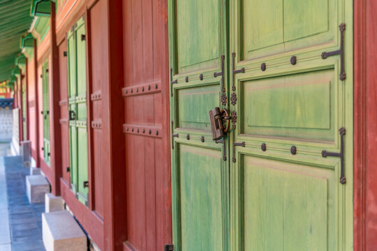 Details of Unhanmun at Changdeokgung Palace show green doors and traditional architecture on a sunny day