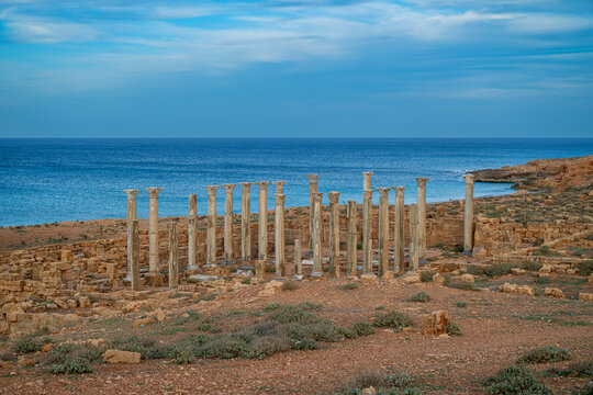 Ruins of ancient Greek columns stand by the coast in Apollonia, Eastern Libya, showcasing historical architecture and natural beauty