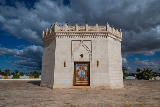 Mausoleum of Omar al-Mukhtar stands in Benghazi under a cloudy sky, showcasing simple architecture and historical significance in Libya