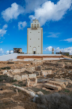 Benghazi Lighthouse stands tall over ancient ruins under a bright blue sky in Eastern Libya