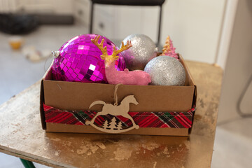 Fototapeta premium Colorful decorations in a box with a horse figure and a plaid ribbon for holiday events
