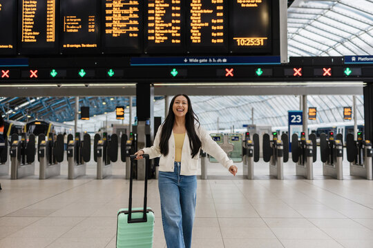 Traveler arriving at London train station feeling happy