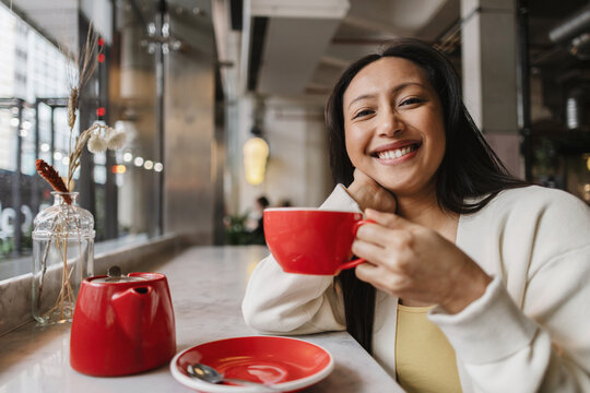 Asian Woman ethnicity enjoying tea time at a cafe
