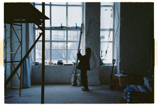 Female inspector taking photo of renovation quality in large room