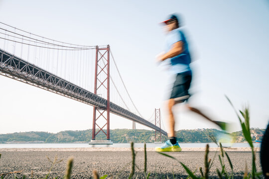 Running Near a Large Bridge on a Sunny Day in Lisbon