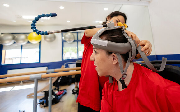 Therapist assisting young woman with head mounted device