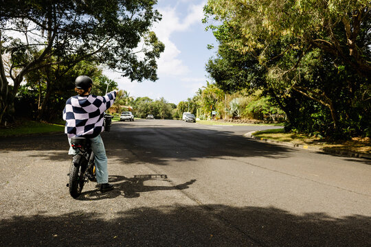Man paused on e bike pointing down residential street