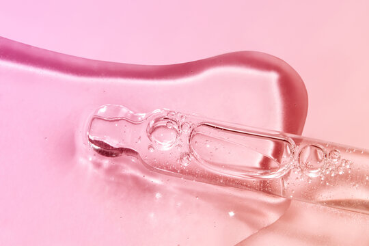 Close up of Glass Pipette with Face Serum on Gradient Background