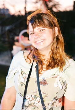 Young Woman Smiles at Outdoor Event During Twilight Hour