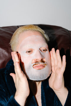 Man Applying Sheet Face Mask During Skincare Routine