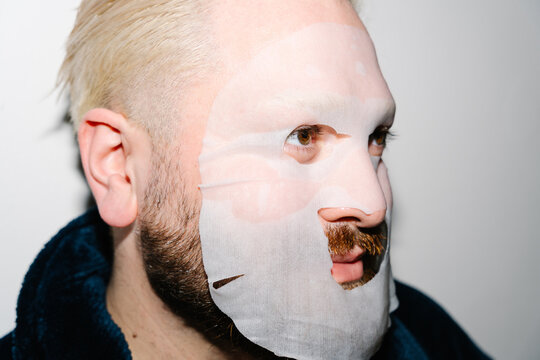 Close Up Of Man Wearing Sheet Face Mask
