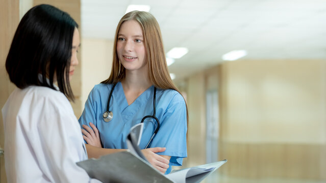 Compassionate young nurse discussing healthcare information with a patient in a modern hospital creating confidence trust and quality medical care.
