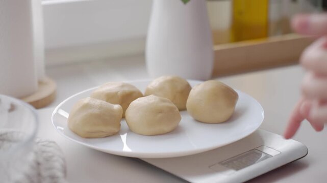 Making dough balls for baking, with hands shaping dough portions