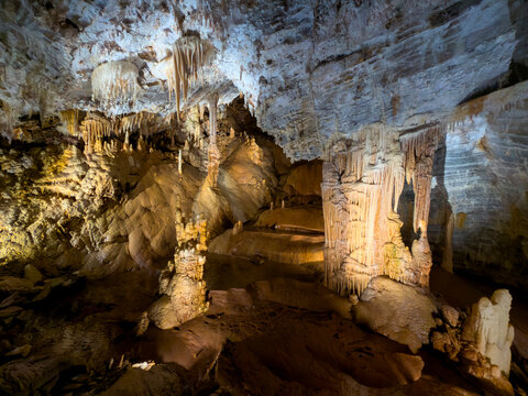 Illuminated Cave Chamber with Stalagmites and Still Water