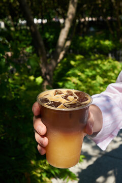 Anonymous woman holding coffee with ice