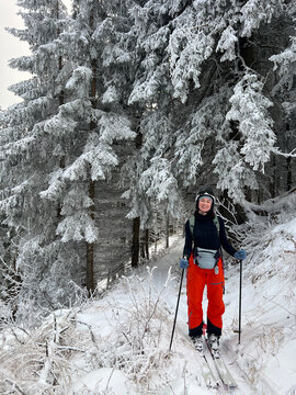 Happy woman enjoying a ski touring adventure in winter.