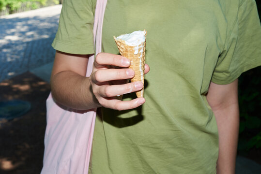 Anonymous teenager holding an ice cream in a cone