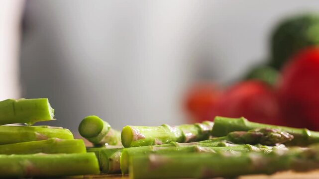 Fresh green asparagus on kitchen with broccoli and green pepper, vegan healthy food. Bunch of green asparagus close-up