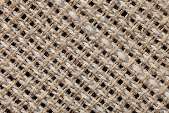 Macro close-up of a beige 54% linen 46% polyester fabric blend, showing individual fibers and woven texture detail for textile backgrounds.