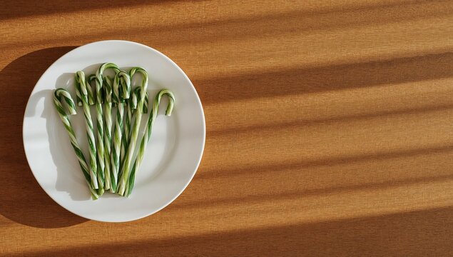 freshly cut sugar canes artfully arranged on white ceramic plate left side composition on rustic wood table natural soft light vibrant green stems organic farm produce food photography healthy eating