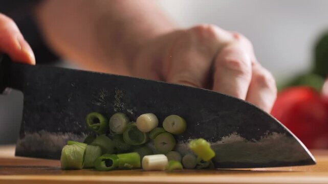 Bunch of green onion feathers with drops of water on a cutting board, Close-up macro rotating shot. 