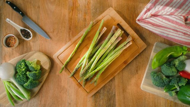 Fresh green asparagus on kitchen with broccoli and green pepper, vegan healthy food. Bunch of green asparagus close-up