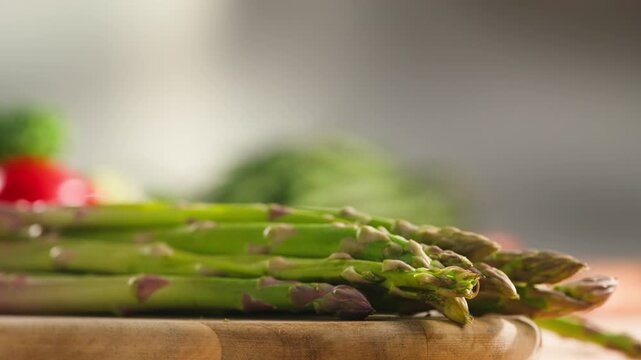 Fresh green asparagus on kitchen with broccoli and green pepper, vegan healthy food. Bunch of green asparagus close-up