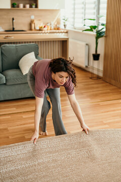 Woman preparing to clean living room area rug