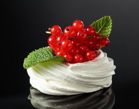 Pavlova dessert with red currant and mint.