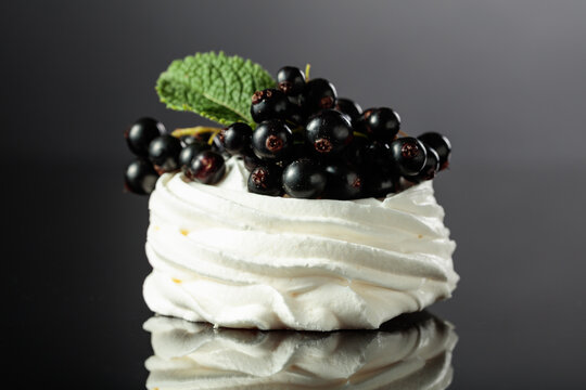 Pavlova dessert with black currant and mint.