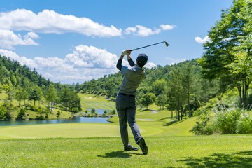 Obraz premium 壮大なゴルフ場で男性が力強くスイングする様子を捉えた夏の屋外