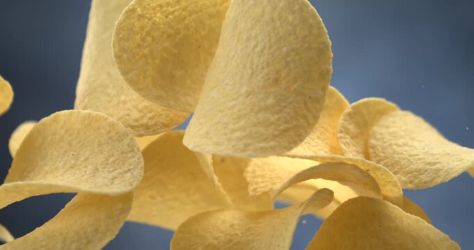 Potato chips falling in slow motion 1000 fps against blue background