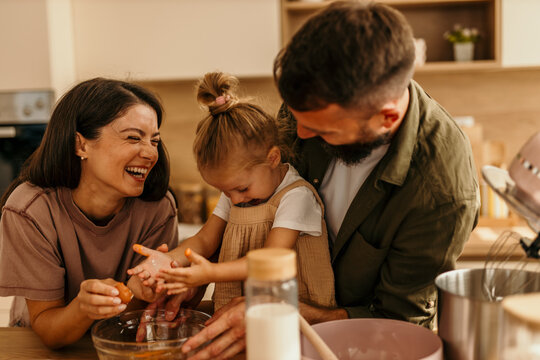Happy family baking together in kitchen laughing