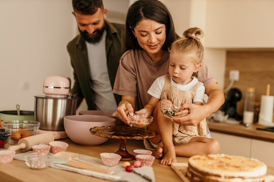 Family baking cake together in kitchen at home