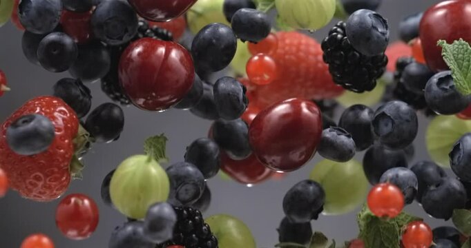 Mixed fresh berries floating in super slow motion on black background