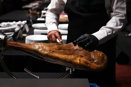 profesional maestro cortador jamonero limpiando el tocino de un jam&oacute;n ib&eacute;rico