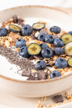 Healthy yogurt bowl with fresh blueberries granola and chia seeds in a rustic ceramic dish for a nutritious and delicious morning meal