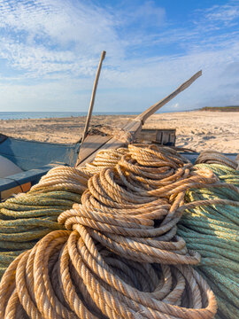 Fishing ropes on a traditional wooden boat on the sunny sandy beach of Ovar Portugal with a clear blue sky background for a nautical seaside scene
