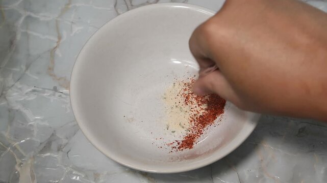 Pouring Instant Noodle Seasoning Powder and Oil into a White Bowl
