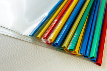 Fototapeta premium The ends of colored binder clips lie together on an office desk.