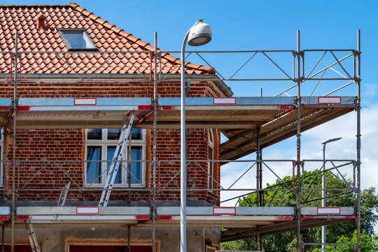 Restoration of a historic brick building with facade scaffolding in summer