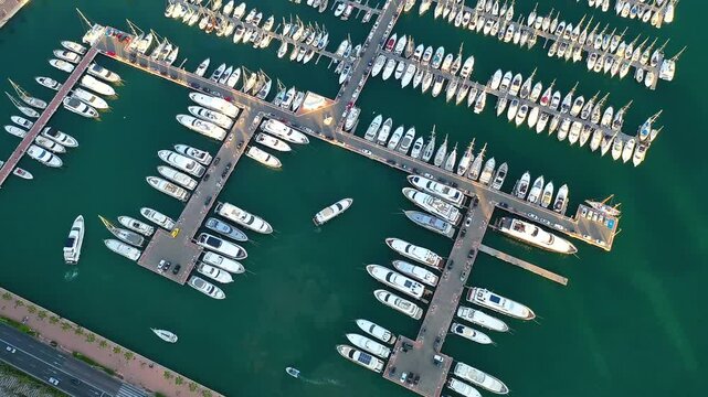 Aerial view of a yacht entering in Marina Alicante, Spain, with others moorings in the Mediterranean Sea.