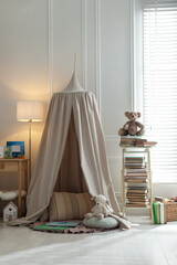 Beautiful wigwam, different toys and books in child's room. Interior design © New Africa