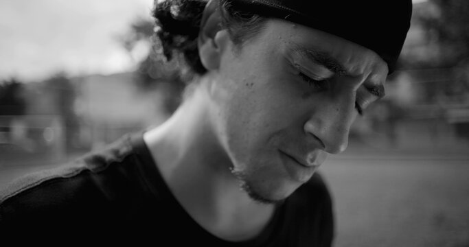 Close-up Hispanic man showing visible frustration and anger, expression filled with regret and annoyance, reflecting emotional tension and inner conflict, black and white
